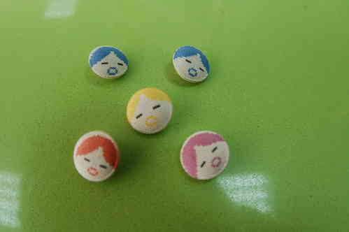 Lined buttons with cloth. Faces of dolls