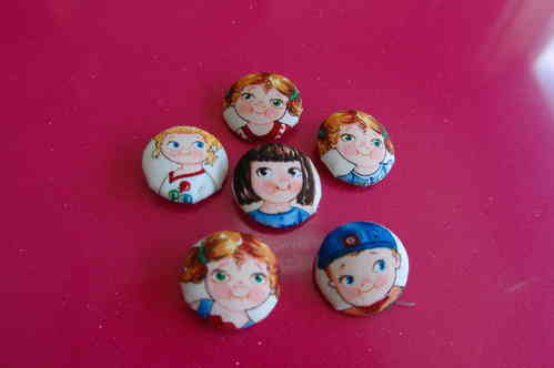 Lined buttons with cloth. Cutted faces of dolls
